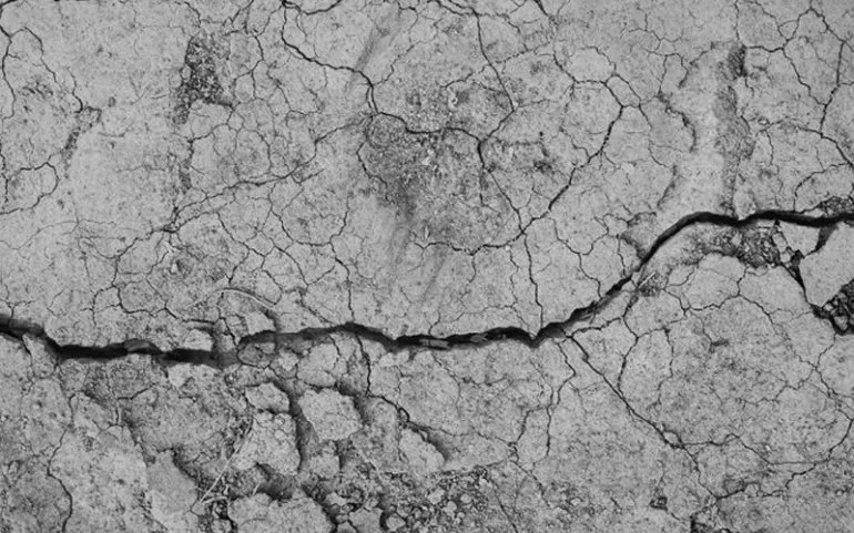 Close-up of crumbling concrete foundation wall deterioration